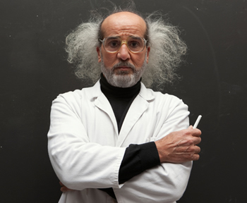 A professor wearing a white lab coat standing in front of a chalkboard; Shutterstock.com