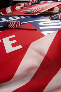 American flags draped over table with vote signs