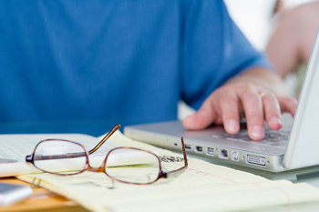 a pair of glasses next to a laptop computer