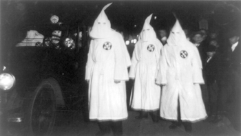 three men dressed in Klan garb