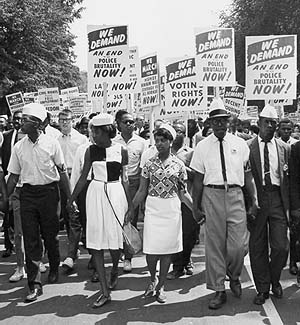 Marchers carrying signs protesting discrimination