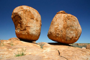 Devil’s Marbles, showing two very large boulders poised atop another rock. 