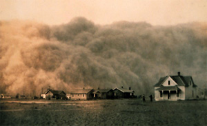 a large cloud of dust moving over the landscape