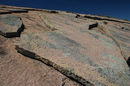 rock being weathered by pressure release, with large sheets of it being broken off from the surface