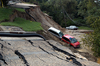 cars that have been damaged because of a road collapse