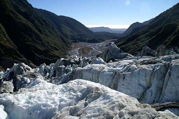 A glacier flowing in between two high mountains.