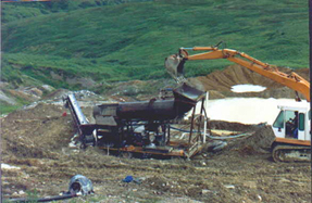 an excavator extracting materials from a large hole