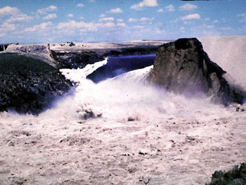 water rushing through a failed dam