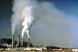 a power plant with smoke coming from the smokestack