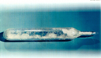 a glass container holding crystals of uranium hexafluoride