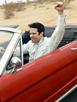 A man driving a convertible with the top down