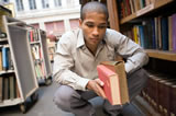 A man holding books in a library.