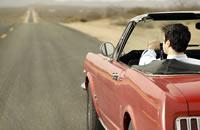 A man driving in a convertible.