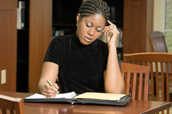 A woman writing in a library.