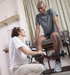 Man with knee injury and a nurse assisting him