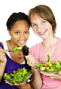 Two students eating a healthy salad; Shutterstock.com
