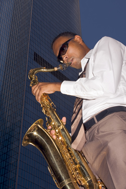 A man playing the saxophone in the city; Shutterstock.com