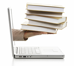 A hand holding a stack of books from a laptop screen; ThinkStock.com