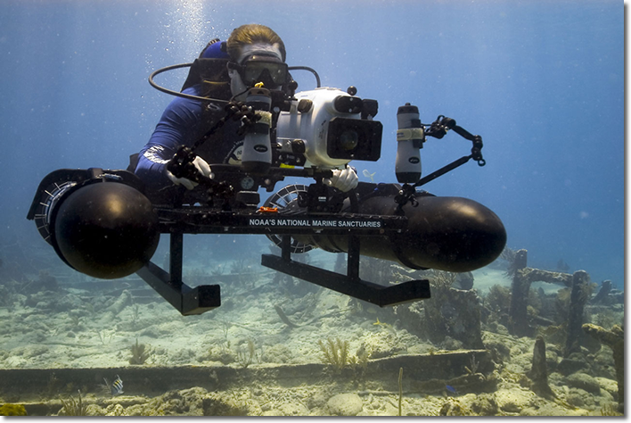 A NOAA archaeologist photographs a wreck site in Florida Keys National Marine Sanctuary using specially a constructed sled mounted with a high-resolution camera.