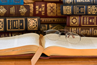 An opened book with eye glasses on top; Shutterstock.com