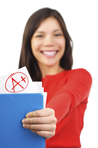 A female student holding A+ and a notebook