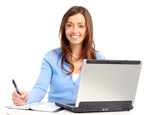 A lady sitting behind her laptop in a desk holding a pen