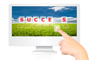 A finger pointing to the letter s of success written across a computer screen; Shutterstock.com