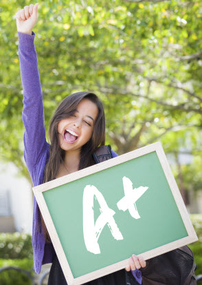 Girl holding graded paper with a score of 100%.