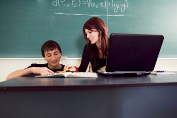 Student and teacher working on a computer
