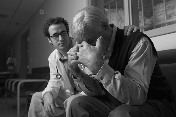 Doctor sitting with a grieving man