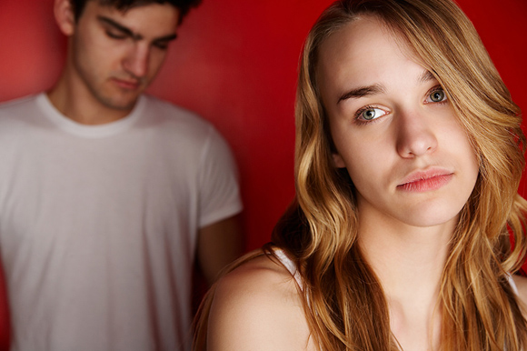 Teen girl looking worried, teen boy in background