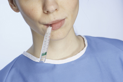 Teen boy with a thermometer in his mouth